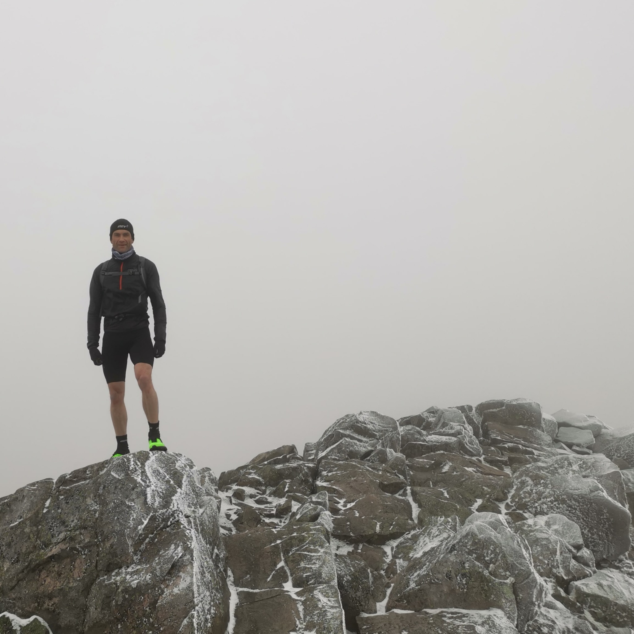 Will standing on a rocky hill summit in misty conditions